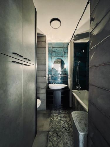 a bathroom with a sink and a toilet and a tub at Klimatyczny apartament Złotniki in Wrocław
