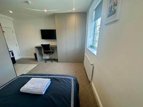 a bedroom with a bed and a desk and a chair at Spectacular Modern, Private Apartment,15 Mins To Central London in Hendon