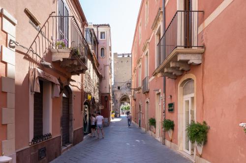 an alley in an old town with people walking down it at Th Luxury Apartment Taormina in Taormina