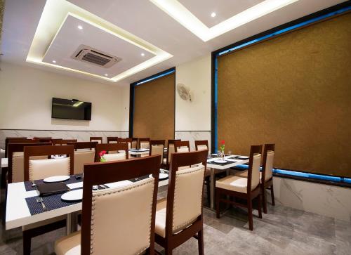 a dining room with tables and chairs and a large window at Hotel Z Suites - Delhi Airport- FREE Airport Pickup & Drop in New Delhi