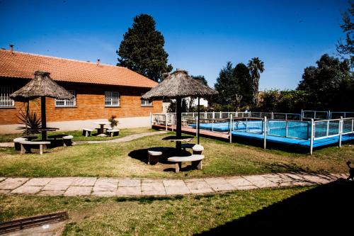 una piscina con bancos y sombrillas junto a un edificio en Clima Sol, en Merlo