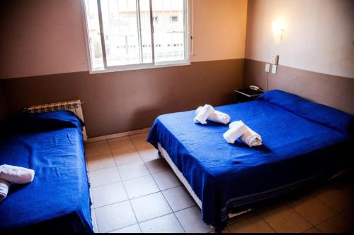 Un dormitorio con dos camas con toallas encima. en Clima Sol, en Merlo