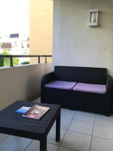 d'un canapé installé sur un balcon avec une table. dans l'établissement Le Carre Montfleury Cannes, à Cannes