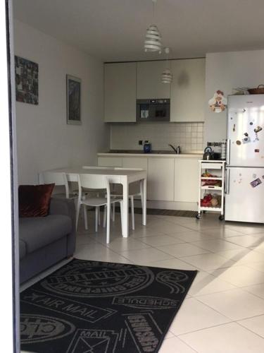 une cuisine avec une table, des chaises et un réfrigérateur dans l'établissement Le Carre Montfleury Cannes, à Cannes