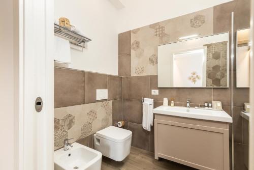 a bathroom with a sink and a toilet and a mirror at Aras Hotel Boutique in Villasimius