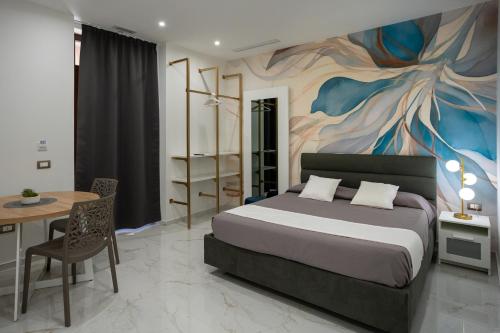 a bedroom with a bed and a painting on the wall at Th Luxury Apartment Taormina in Taormina