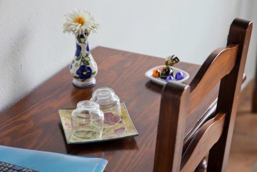 a wooden table with a vase and a plate of flowers at Casa Velarde in Torrelavega