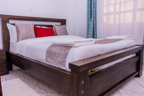 a large bed with a wooden frame in a bedroom at Ebony 1br 41 Nanyuki in Nanyuki