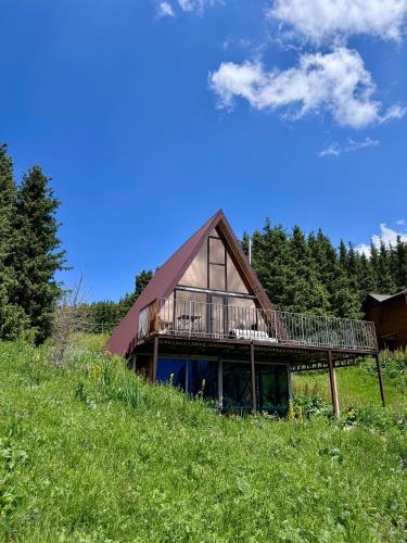 a house on top of a hill with a deck at Fantastic view - Chalet Karakol in Karakol