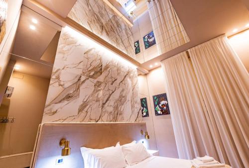 Una habitación de hotel con una cama y una pared de mármol. en GM Luxury Apartment, en Palermo