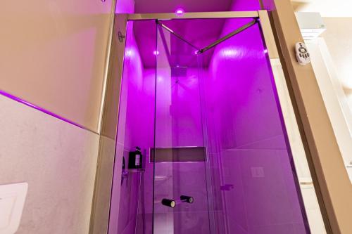 y baño con ducha con iluminación rosa. en GM Luxury Apartment, en Palermo