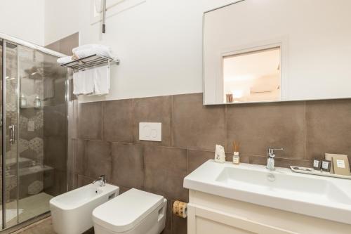 a bathroom with a sink and a toilet and a mirror at Aras Hotel Boutique in Villasimius