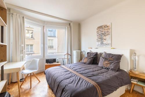 une chambre avec un lit, un bureau et une fenêtre dans l'établissement Copernic- CI - Apt for 2 p 10 min from Arc de Triomphe, à Paris