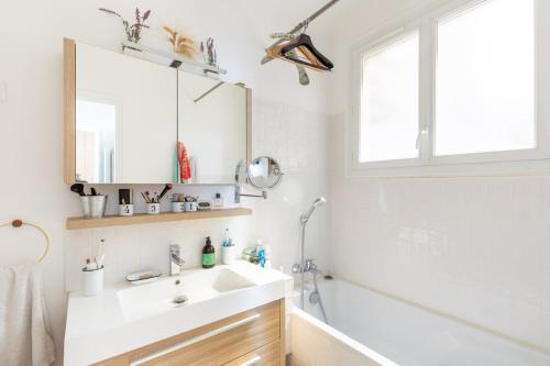 une salle de bain blanche avec un lavabo et une douche dans l'établissement Copernic- CI - Apt for 2 p 10 min from Arc de Triomphe, à Paris