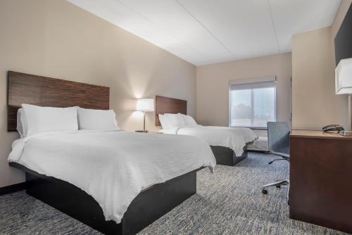 a hotel room with two beds and a desk at Garner Hotel Panama City Beach Northeast by IHG in Panama City Beach