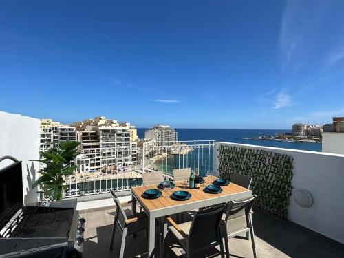 a table on a balcony with a view of the ocean at Duplex Penthouse Prime Location in St Julian's