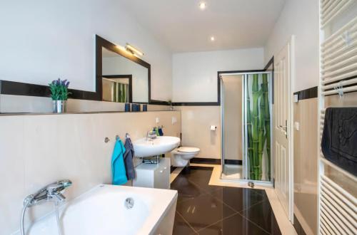 Bilik mandi di Ferienwohnung Creutzer in Leipzig Gottscheina, ideal auch für Monteure, kostenfreies, schnelles Wlan kostenfreies Parken, geräumiges Appartment mit 4 Einzelbetten, Komplettausstattung Küche, Bad mit Badewanne und Dusche Waschmaschine, Wäschetrockner