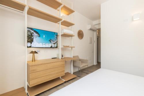 a bedroom with a tv on the wall at Aras Hotel Boutique in Villasimius