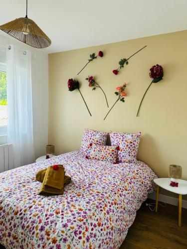 - une chambre avec un lit orné de fleurs sur le mur dans l'établissement Le Sauge Centre Fougères, à Fougères