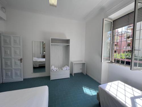 a white room with a bed and a mirror at Green Park San Pancrazio in Rome