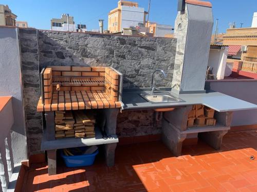 a kitchen with a sink and some bricks at Apartamento El Atardecer in El Perelló