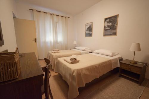 a hotel room with two beds and a table at Apartment Poli šterne, two rooms and pet friendly in Rakalj