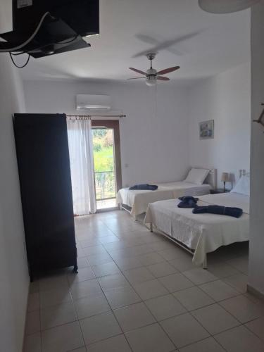 a hotel room with two beds and a window at Agnanti Kotsikia in Kotsikiá