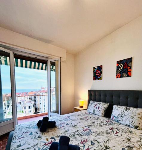 une chambre avec un lit et une grande fenêtre dans l'établissement Azure Horizons Seaside Escape, à Beaulieu-sur-Mer