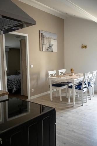une salle à manger avec une table et des chaises blanches dans l'établissement T3 lumineux dans maison avec jardin terrasse et parking Vallee de l Eyrieux, à La Voulte-sur-Rhône