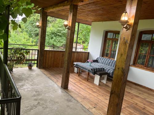 イジェヴァンにあるHarmony Guest Houseのデッキにベンチがある網戸付きのポーチ