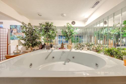 a large white bath tub in a room with potted plants at 3 Mi to Garden of the Gods Quiet Home with Hot Tub! in Colorado Springs