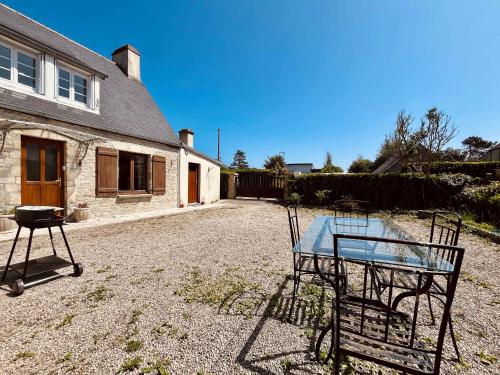 a table in the yard of a house at La Maison d Utah Beach and Memory in Sainte-Marie-du-Mont