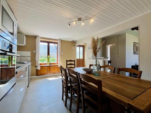 a kitchen and dining room with a wooden table and chairs at La Maison d Utah Beach and Memory in Sainte-Marie-du-Mont