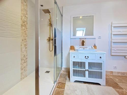 a white bathroom with a sink and a shower at Kerinou in Guimaëc