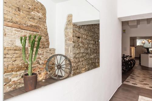 a stone wall with a wheel on a wall at Aras Hotel Boutique in Villasimius