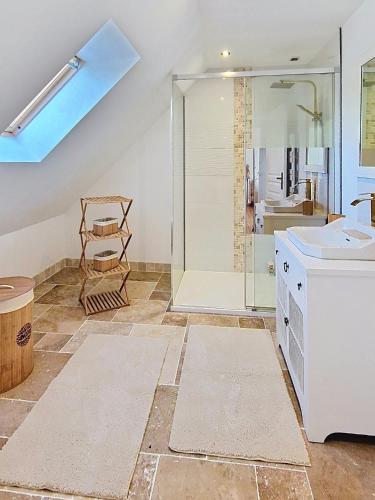 a bathroom with a glass shower and a sink at Kerinou in Guimaëc