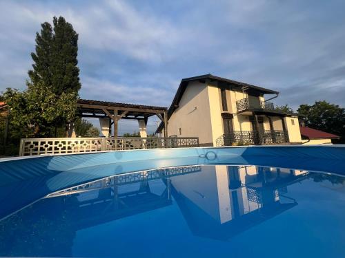 a house and a swimming pool in front of a house at Holiday Home Nirvana in Gornji Mihaljevec