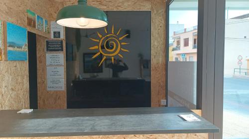 a glass window with a sun sign on it at Hostel Elios in Lorca