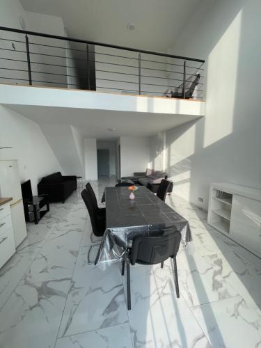 une salle à manger avec une table et des chaises noires dans l'établissement Grand Maison COCO proche Disney, à Coulommiers
