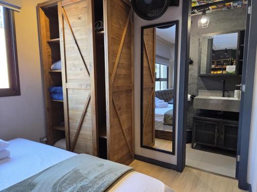 a bedroom with a mirror and a sink at CPR26 - Studio Com Arquitetura Industrial no Juvevê- Curitiba in Curitiba