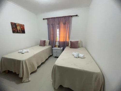 a room with two beds with towels on them at Family Apartment in San Isidro in Mendoza