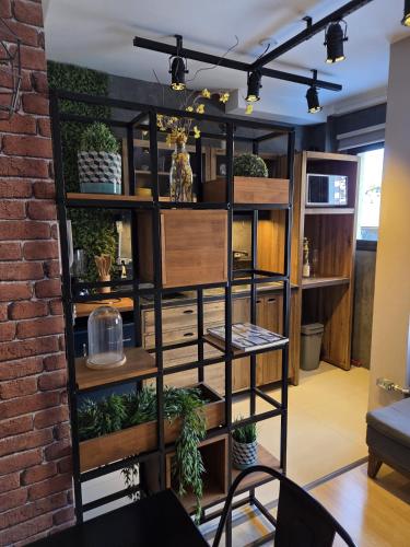 a room with a book shelf with potted plants at CPR26 - Studio Com Arquitetura Industrial no Juvevê- Curitiba in Curitiba