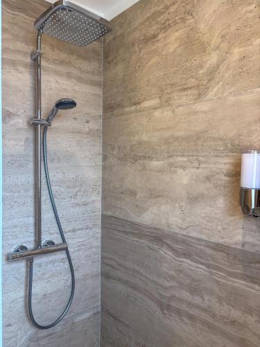 une douche avec pommeau de douche dans une salle de bain dans l'établissement Maison sol en ciel Petit Dejeuner et Parking inclus, à Aigues-Mortes