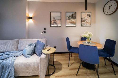a living room with a couch and a table at Apartamenty i Pokoje Złotobrzeg in Sarbinowo