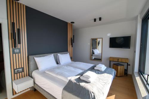 a bedroom with a large bed with white sheets at Villa Marmonte, Luksuzna vila s bazenom i pogledom na more in Medveja