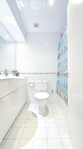 a white bathroom with a toilet and a sink at CSS Cheerful Smart Superior 2BD Townhouse Limnaria Gardens in Paphos City