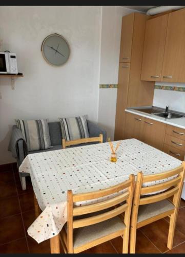 a kitchen with a table and chairs and a kitchen with a table and a table at Apartamentos el Olivo in Trias