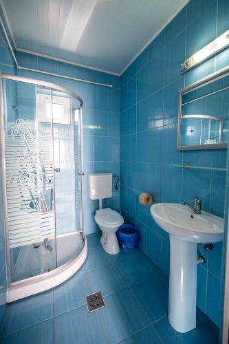 a blue bathroom with a toilet and a sink at Casa Amalia in Costinesti