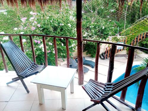 Villas Akalan في تولوم: كرسيان وطاولة على شرفة بها مسبح