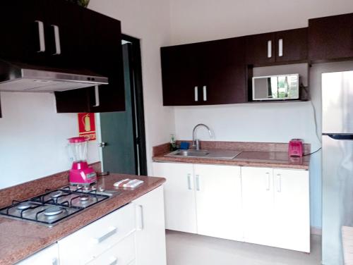 una cucina con mobili bianchi e un forno con piano cottura di Villas Akalan a Tulum
